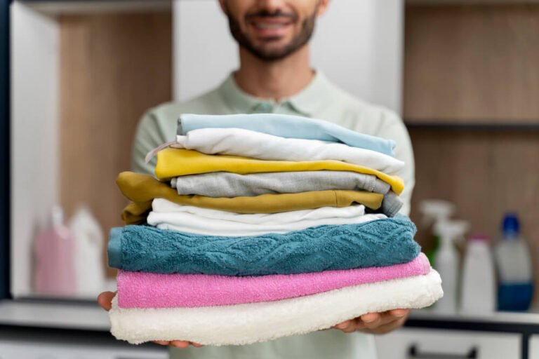 man-holding-pile-clean-clothes (1)